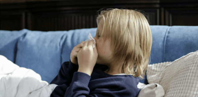 Sick Child Blowing Nose Suffering from Health Effects from Mold Exposure in Home